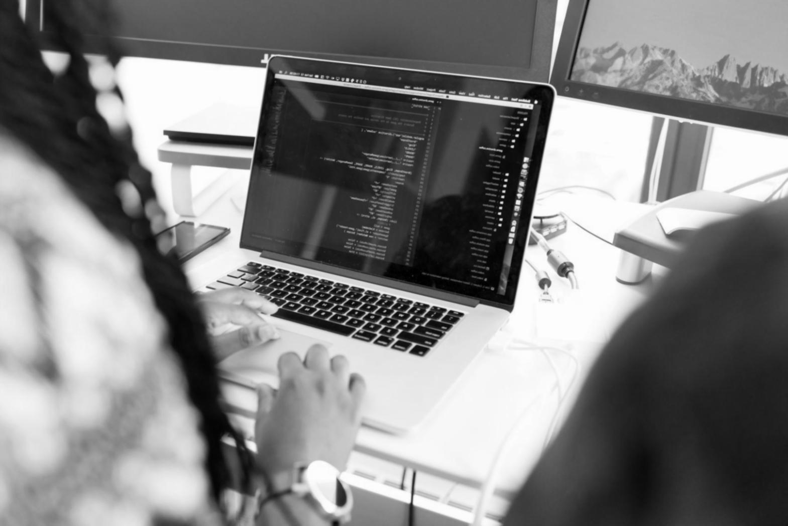 Estudantes a trabalhar em análise financeira com computadores e gráficos